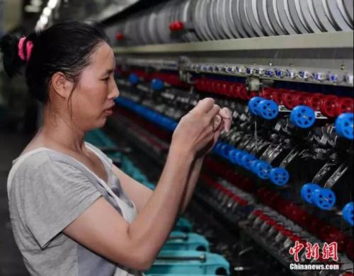 缫丝女工鼻尖上冒着汗珠进行操作管理。中新社发 顾华夏 摄