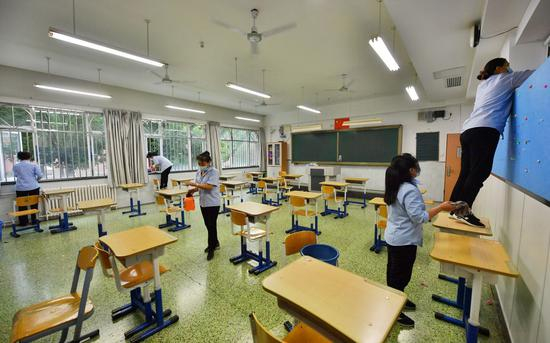 　　7月3日，北京市第十二中学考点，保洁正在对门把手、窗台、地面等进行消杀清洁。摄影/新京报记者 李木易