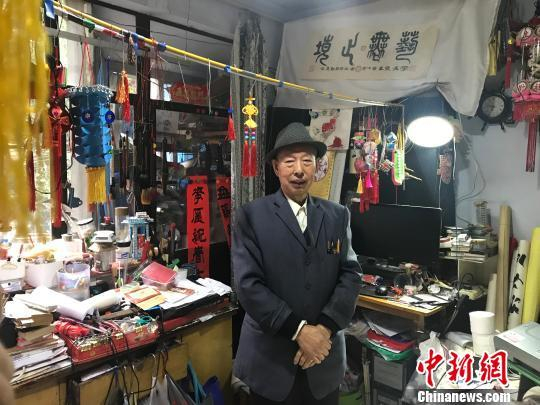 图为郑崇智站在放满自制手工艺品的房间中。　岳依桐 摄