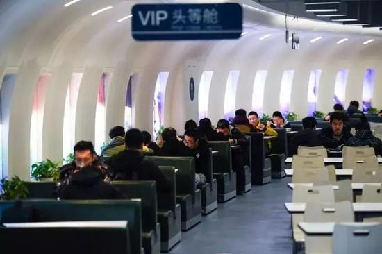 每套桌椅旁都有一扇“舷窗”