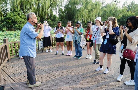 英国学子在天津偶遇公园吹笛老人，图源天津师范大学