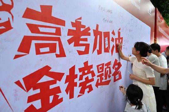 2024年6月6日,在2024年普通高校招生统一考试内江六中考点,考生在签名墙上写下祝福语。视觉中国 图