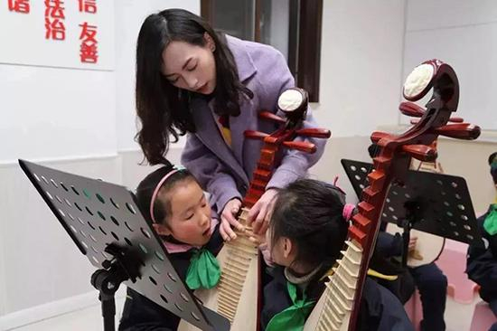 上海市虹口区中州路小学放学后，同学们在老师的指导下练习乐器。（摄影：李立基）