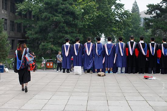 2014年7月，薛逸凡穿着学位服走在北大校园中/图来自视觉中国