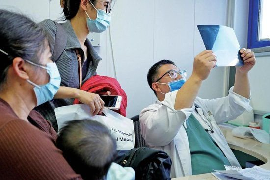 北京儿童医院门诊，医生正在查看影像检查资料。北京儿童医院供图