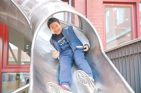 在十一学校龙樾实验中学，学生用滑梯通道走班上课。