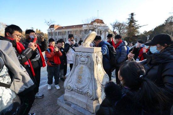 游客在清华大学校园内了解二校门的历史。新京报记者 李木易 摄