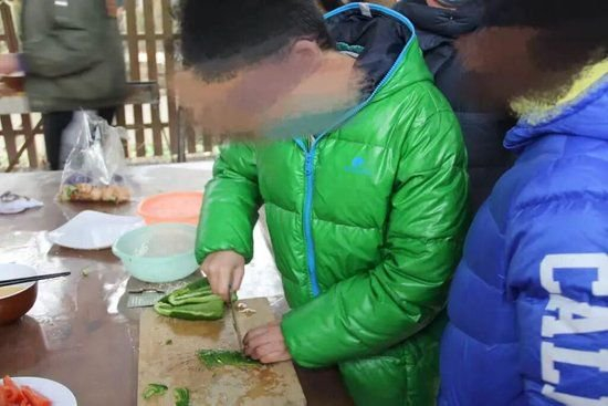 2018年，10岁的小周（左）在2018年冬令营体验动手做菜。受访者 供图