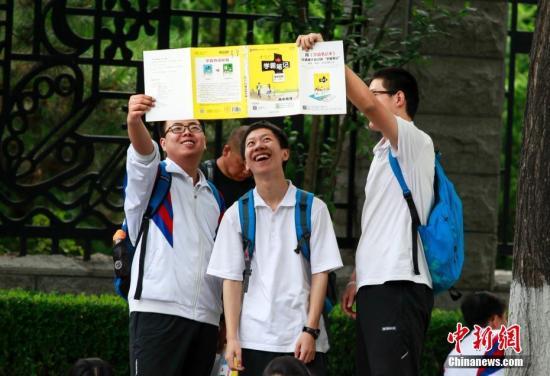 6月8日，全国高考迎来第二天考试日程，北京一考点外考生入场前正在进行最后的复习。 中新社记者 贾天勇 摄