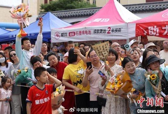 6月8日，宁夏银川市唐徕中学考点，家长手捧鲜花在考场外等候考生。当日，宁夏2024年高考结束。于晶 摄