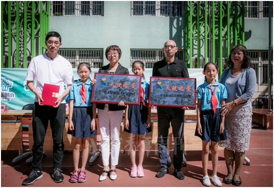 　　升旗仪式后，北京青少年发展基金会秘书长钱蓉晖为北京医科大学附属小学、《北京青年》周刊授牌，为奥运冠军许昕颁发“天使之爱——小天使成长计划公益形象大使”聘书。解飞 摄
