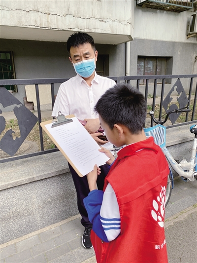 新京报小记者、北京体育馆路小学陈奕涵同学在校门口请家长做未保法调查问卷。马然 摄