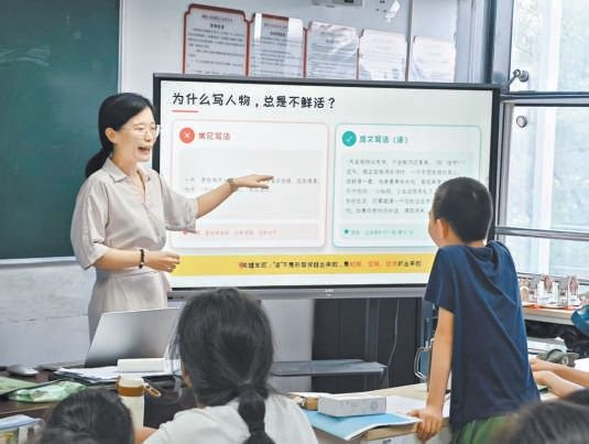 北京晚报作文版编辑白杏珏（左）给孩子们讲解“如何写‘活’人物”。