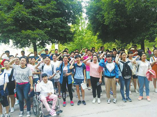 走进考场前，脑瘫女生李某和同学们一起为高考加油鼓劲。
