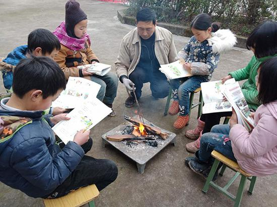 何芙蓉的丈夫在院子里生火，学生们围坐着上课。