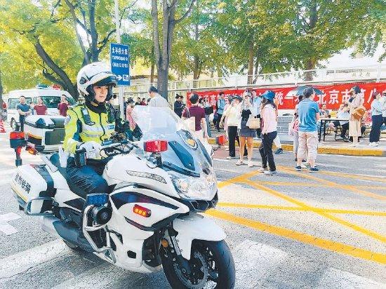 北京八中考点门前,西城铁骑女交警现场疏导交通。