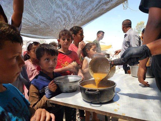 当地时间2024年6月10日，加沙汗尤尼斯，流离失所的巴勒斯坦民众排队等待世界中央厨房（WCK）分发的食物。