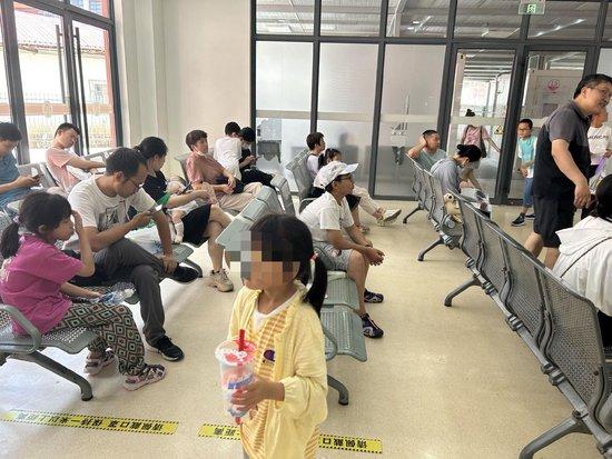 7月25日下午，复旦大学附属儿科医院“学习困难”门诊候诊区坐着家长和孩子。