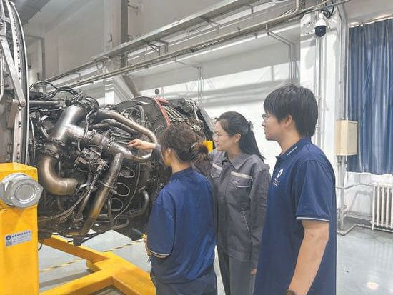 李玮（中）在航空发动机实训基地给学生上课。