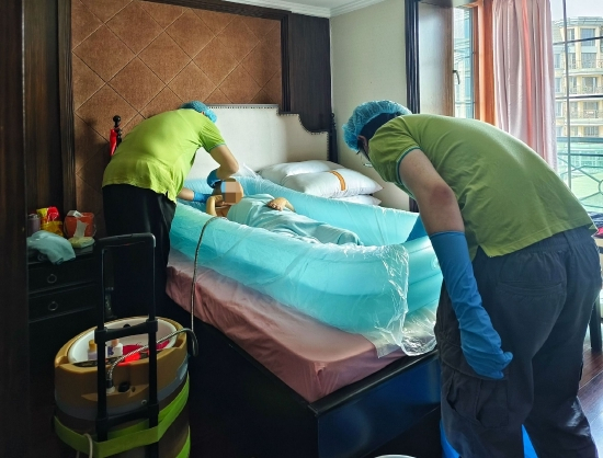 3月8日下午,助浴师在给刘金生洗澡,他躺在“床”上把澡洗了。受访者供图