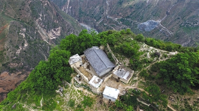 　　5月13日，无人机俯瞰位于悬崖边缘的村民某色拉则的家，他家的后院门推开就是悬崖，房屋所在位置也是全村最高点。