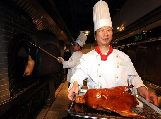 　　资料图：2010年6月6日，焖炉烤鸭技艺第20代传承人白永明（前）烤制出第一只创新“蔬香酥”烤鸭。 新华社记者张旭摄