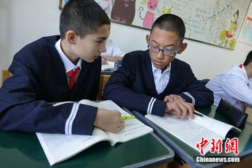 图为穆赫塔巴尔•穆赫塔尔（左一）与同学在课堂上一起研究题目。马学玲 摄