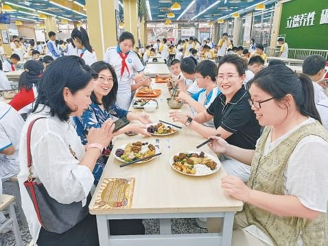 在海淀实验中学食堂，家长志愿者参与陪餐。学校 供图