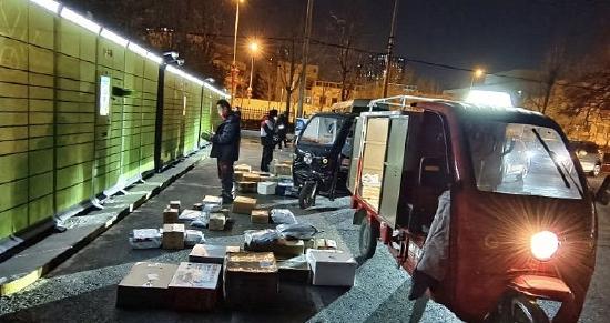 北京丰台某小区,各快递公司挑灯夜战、加班送年货。图片来源:视觉中国