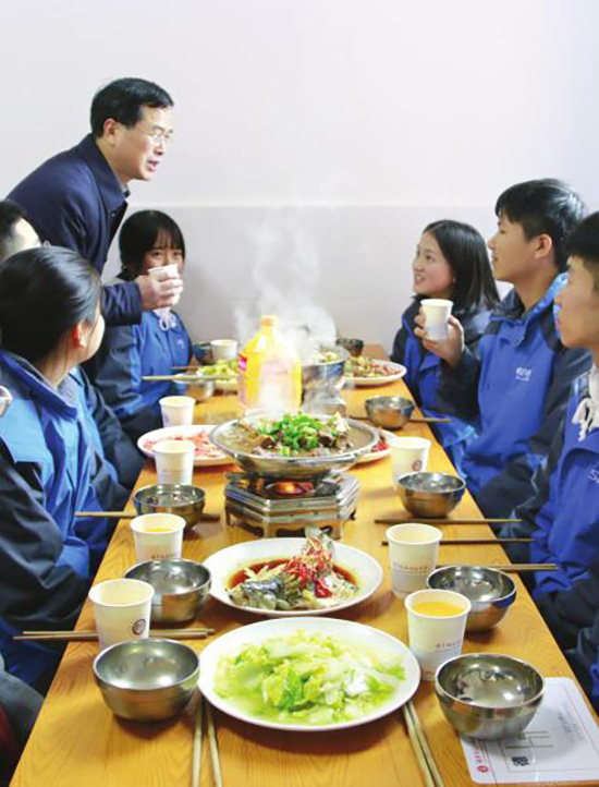 1月17日，湖南师大二附中食堂餐厅，校长张胜利端着饮料和学生们在餐桌上交流。潇湘晨报 图