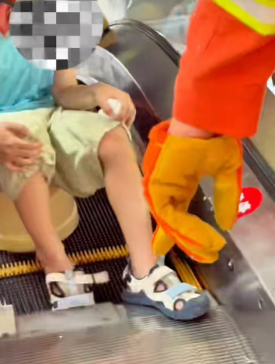 ▲航航在广场乘坐扶梯时，右脚不慎卷入电梯内