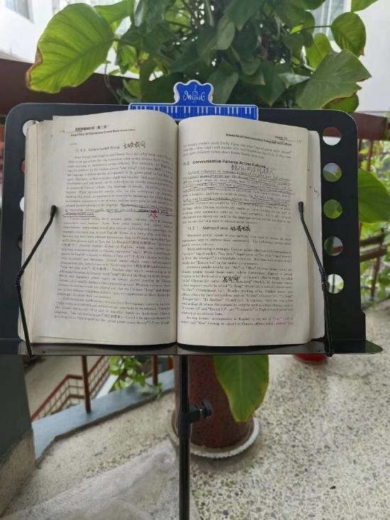 背书太久颈椎疼,小黑买了个乐谱架来放书。