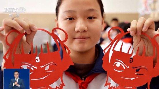 山东青岛的一所小学，一名学生在第一课的活动中展示“哪吒”剪纸。
