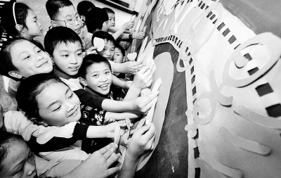 浙江杭州京都小学举办的校园电影节上，孩子们将自己看完电影后写的“三言两语”贴在专栏上。李震宇摄 光明图片/视觉中国