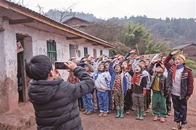 孩子们参加升旗仪式，李华用手机记录下孩子们专注的神情。