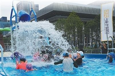 近日，韩国首尔市光化门广场的游乐场内，孩子们在游泳池体验水上项目，增强对水环境的适应能力。