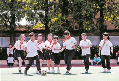 　　在无锡市广新小学操场上，随班就读学生小莹、小俊和同学们一起踢足球。阳光下，孩子们脸上绽放出灿烂的笑容。