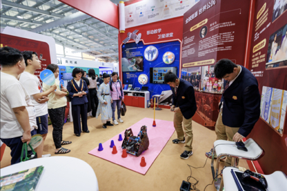 王府学子现场演示机器人，引来服贸会参观者驻足观看