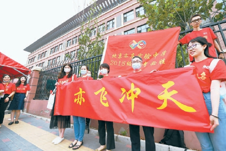 　　今天，北京人大附中经开学校考点，几名老师统一身穿红色T恤，打出横幅为学生加油鼓劲。 本报记者 和冠欣 摄