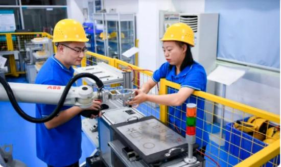 ▲深圳职业技术学院,在ABB机器人实训室,学生们一起练习运行工业机器人。图/新华社