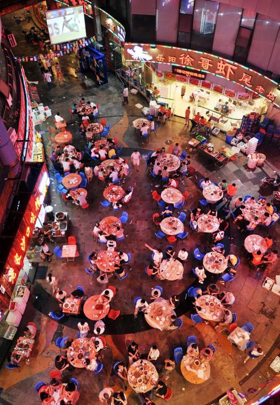 夜里吃小龙虾、喝啤酒看球的长沙人。 图/视觉中国