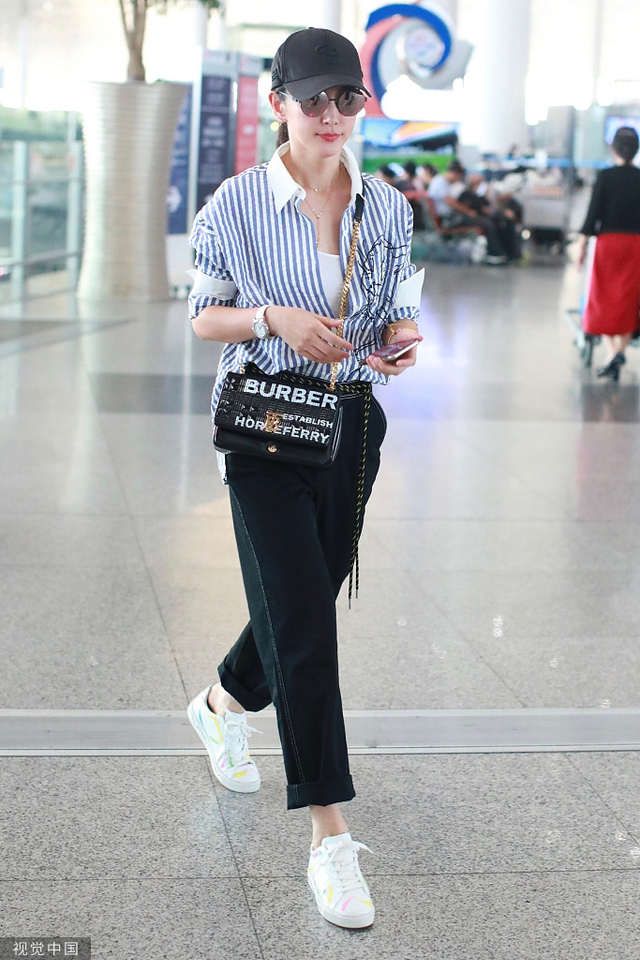 李冰冰现身北京机场,她身穿竖条纹衬衫搭配黑色长裤,脚踩彩色涂鸦运动