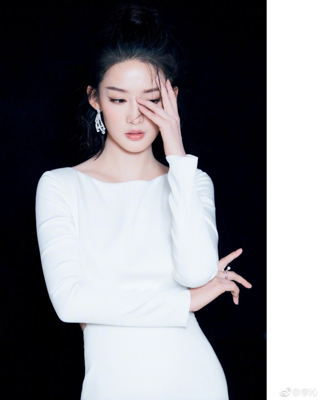 "照片中,李沁戴华丽耳饰贵气十足,贴身长裙秀出纤腰身姿曼妙.