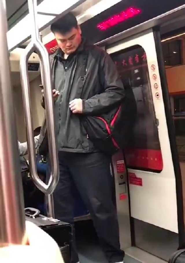 偶遇姚明坐地铁大方朴素 站门口微曲腿低头玩手机_新浪图片