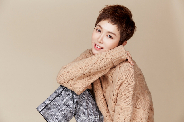 大片中,姜妍一头细碎姜黄短发,黑灰格纹长裤搭配浅黄色的oversize毛衣