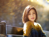 组图：佟丽娅穿拼色毛衣闲坐长椅 沐浴阳光展迷人笑眼