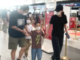 组图：梅婷一家四口现身首都机场 夫妻俩一路牵着孩子画面温馨