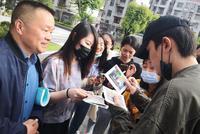 朱一龙衣着朴素回母校探望老师 获师生簇拥签名合照