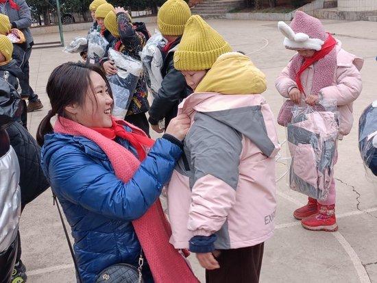 马兰戈尼学院上海校区校长程莹婷女士为小朋友穿上捐赠的棉衣