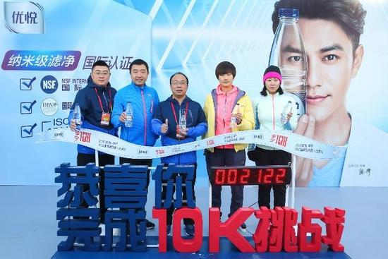 　　康师傅饮品事业北京公司总经理贾俊鹏（左三）与奥运冠军丁宁（右二）、钱红（右一）、杨凌（左二）为跑者加油